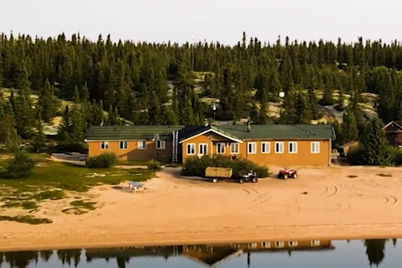 lakeside lodge with 2 quads and trees in background